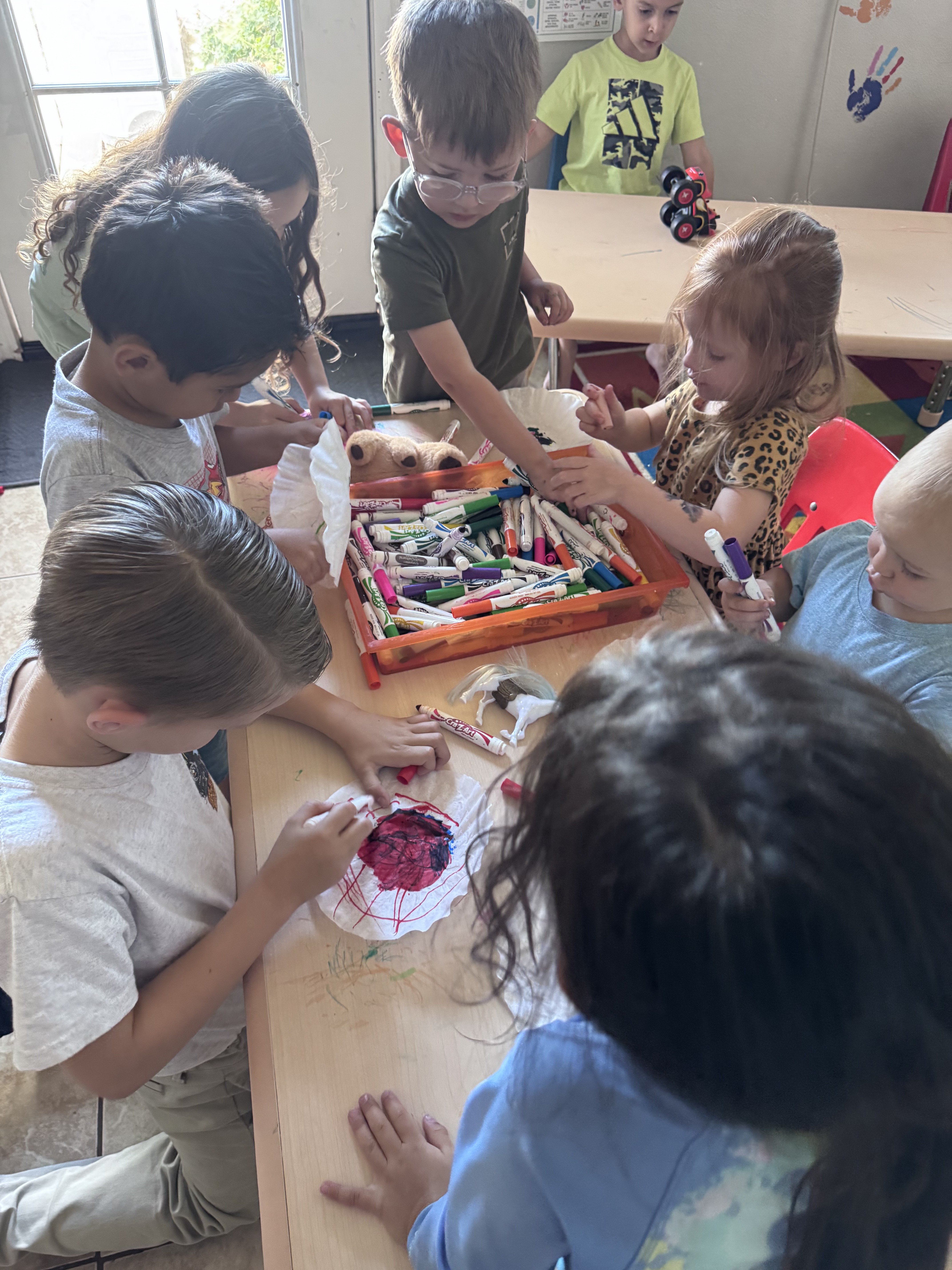 Preschoolers coloring with washable markers at the art table